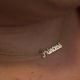 The necklace Mac bought for Alana, based on his nickname for her.